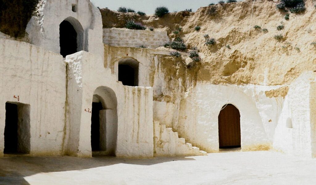 Traditional underground homes in Matmata, Tunisia, with sunken courtyards and whitewashed cave entrances built into the hillside.