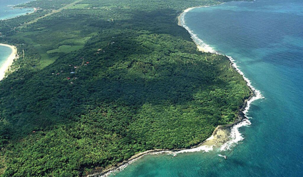 Aerial view of lush green coastline and clear blue waters in Nicaragua.