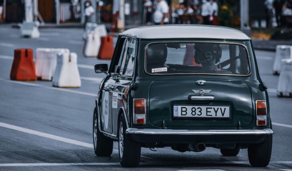 Vintage Mini Cooper driving through a closed road course, symbolizing retro travel and navigating without modern GPS.