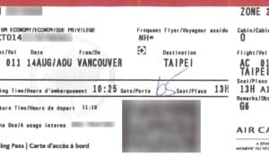 Printed airline boarding pass with flight details, including destination, seat number, and boarding time.