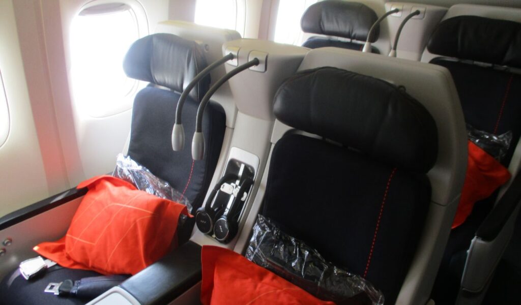 Premium economy or business class seats with privacy headrests, reading lights, and pillows—ideal for quiet, relaxed flying.