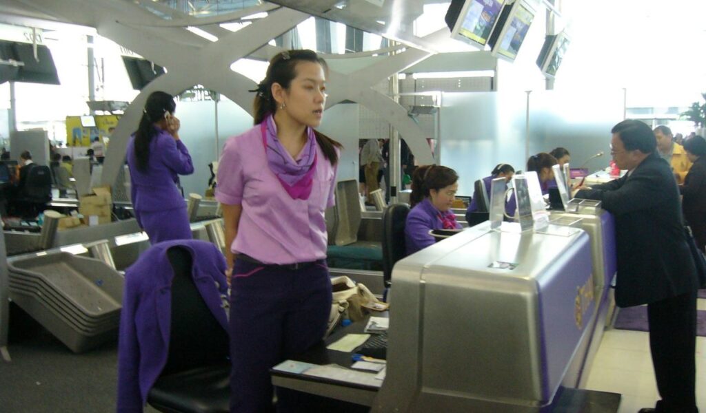 Airline staff assist passengers at check-in counters, helping ensure a smooth and quick boarding process.