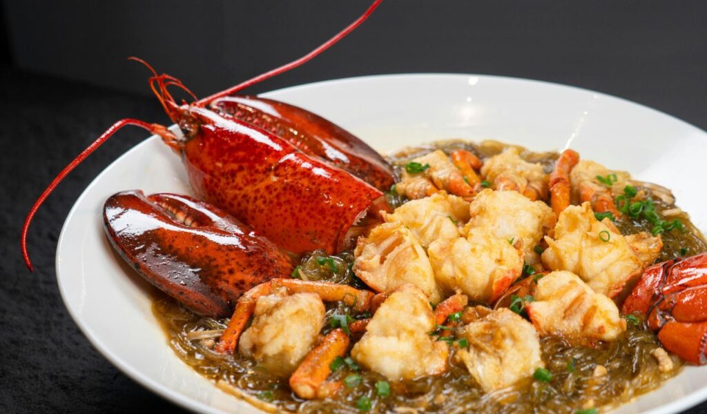 A plate of Red Lobster’s signature seafood dish featuring fried lobster pieces with noodles, garnished with herbs, served in a rich sauce.