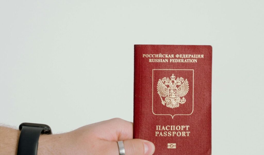 Person holding a Russian passport, symbolizing important travel documents needed for international trips.