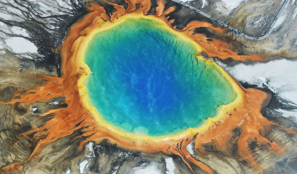 Aerial view of Grand Prismatic Spring with vivid blue, green, and orange thermal rings.