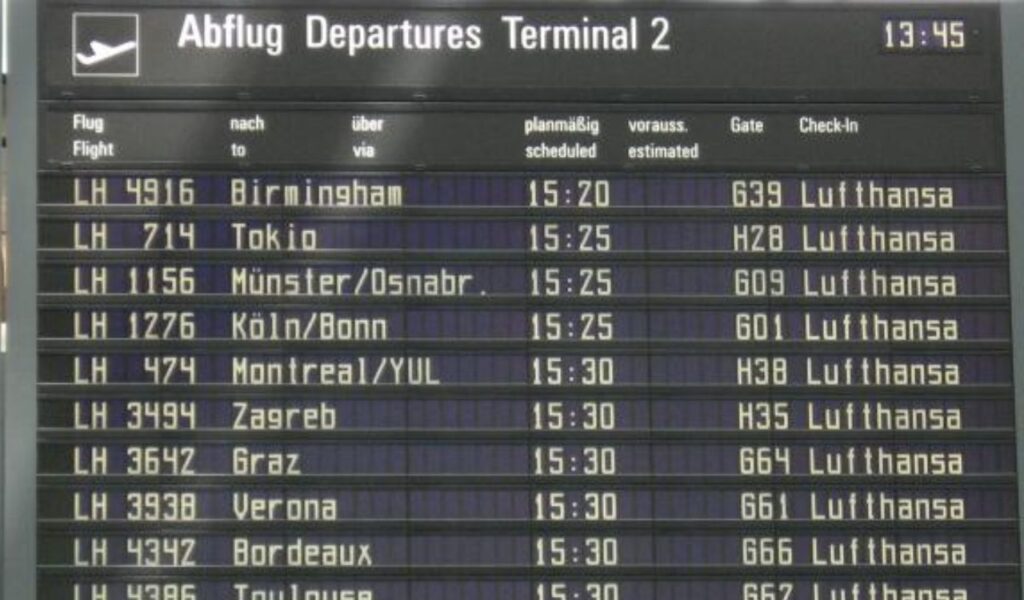 Close-up of a German airport departure board in Terminal 2 showing multiple Lufthansa flights and scheduled times.