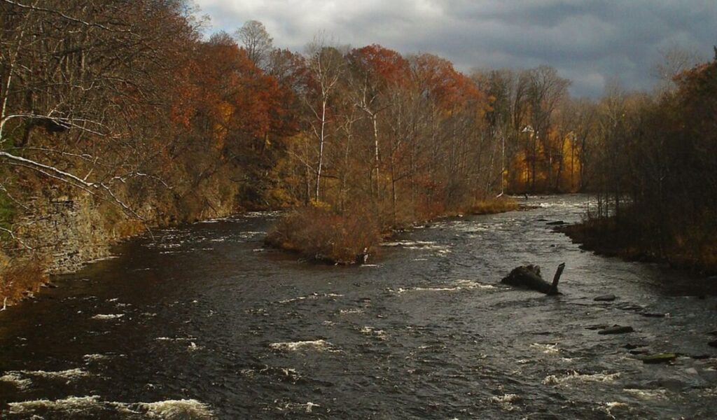 Sunbeam Hot Springs river view with autumn trees and cloudy sky in Idaho.