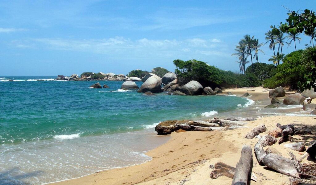 Secluded beach with palm trees and boulders in Tayrona National Park, Colombia