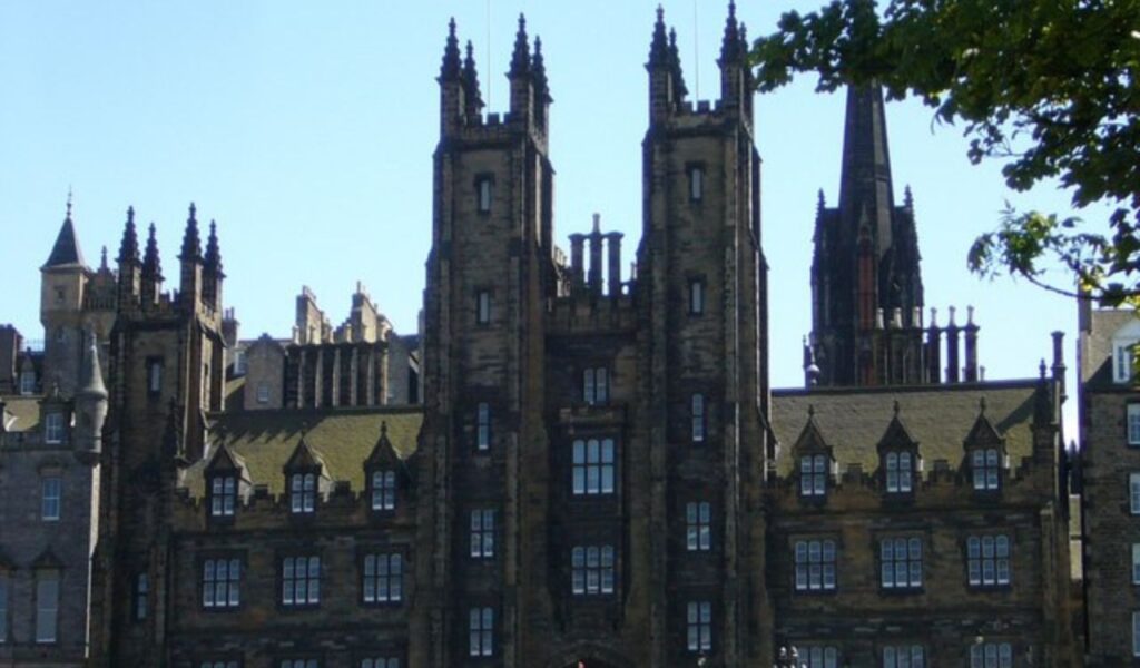 Historic architecture of a gothic-style building with tall towers and intricate details in Edinburgh, Scotland