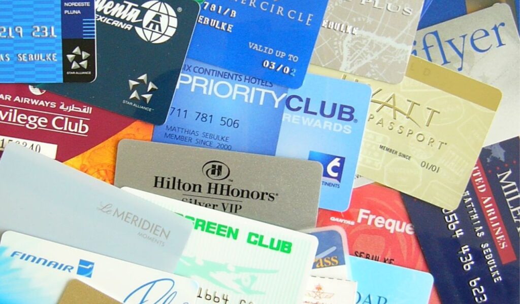 Assorted airline and hotel loyalty program cards arranged in an overlapping pile, showing various rewards memberships.