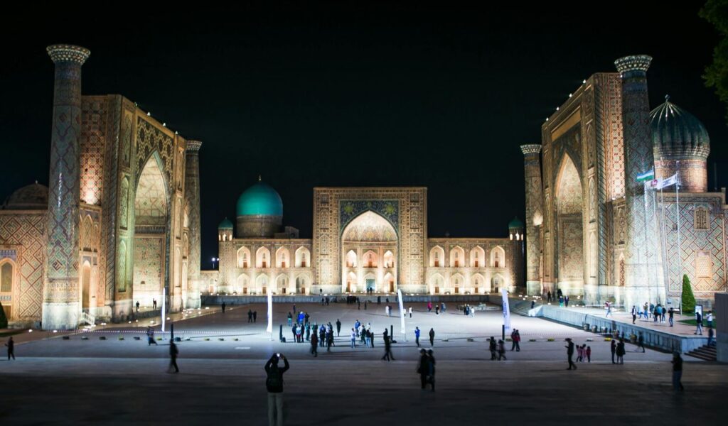 Night view of Registan Square with illuminated madrasahs in Samarkand, Uzbekistan.