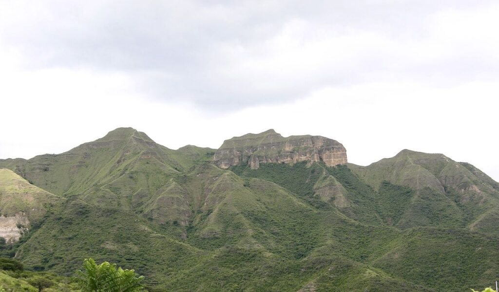 Lush green mountains under cloudy skies in Vilcabamba, Ecuador, known for scenic hiking views.