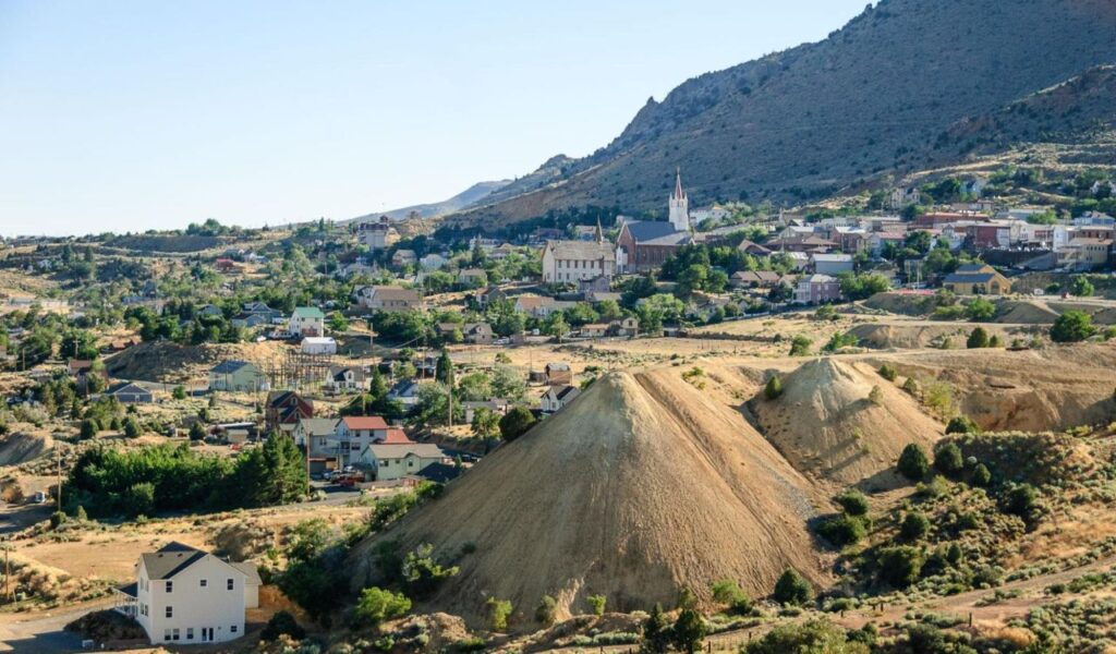 Hilly landscape view of Virginia City, Nevada, with historic buildings and mining mounds.