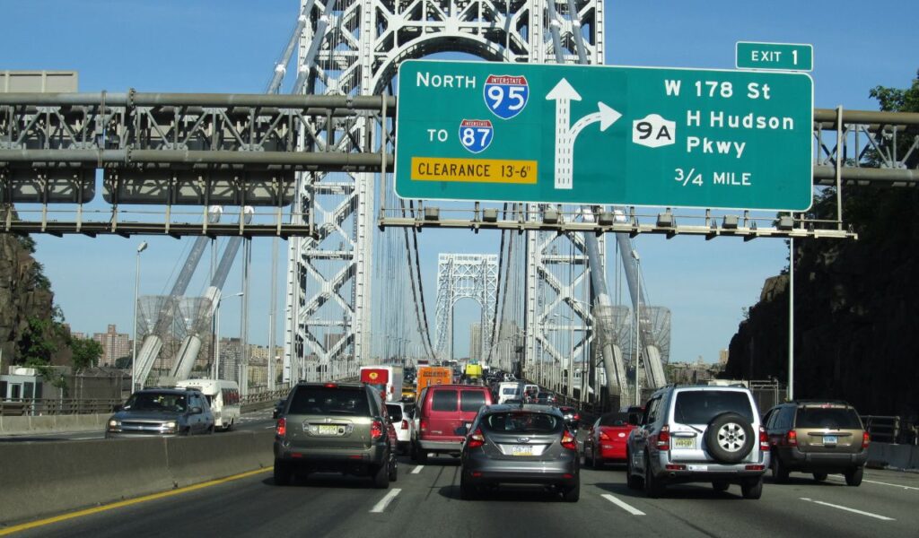Heavy traffic crosses a bridge on Interstate 95 during a sunny day, highlighting seasonal road travel challenges.