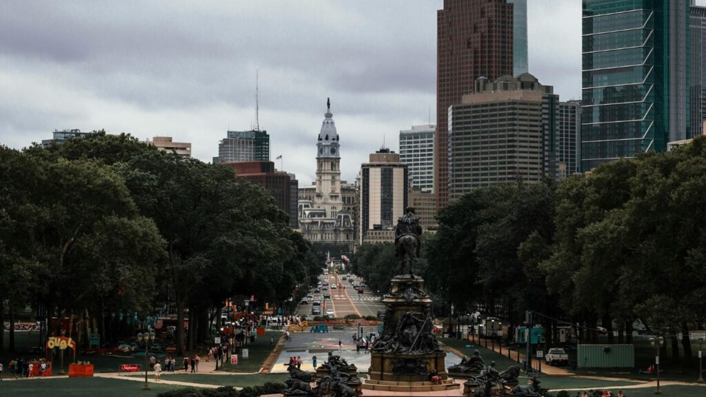 View of Philadelphia’s skyline from the art museum steps, with City Hall in the distance and a historic fountain in the foreground.