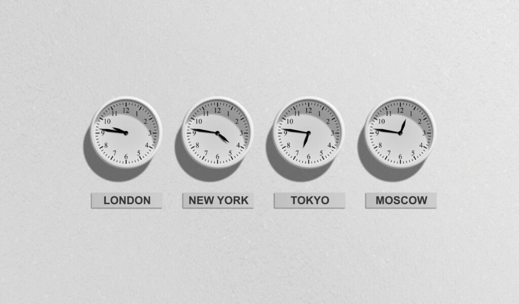 Four wall clocks displaying different times labeled for London, New York, Tokyo, and Moscow on a white background.