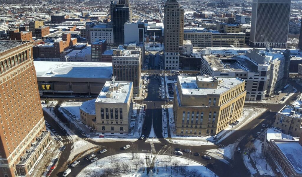 Aerial view of downtown Buffalo, New York, showing snow-covered streets, historic buildings, and modern high-rises on a clear winter day