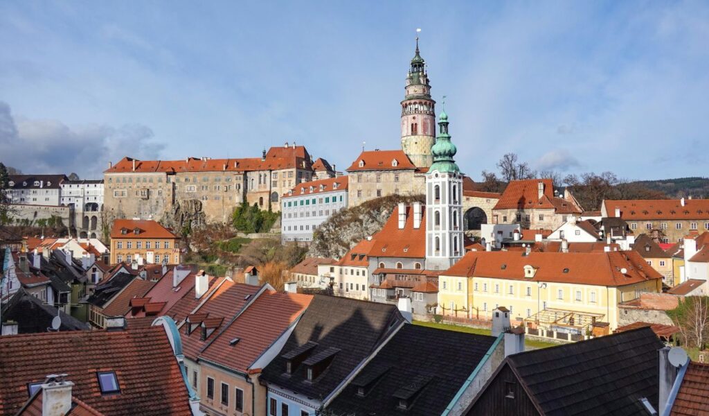 Cesky Krumlov Castle in the Czech Republic with its tower and historic buildings overlooking red-roofed townhouses.