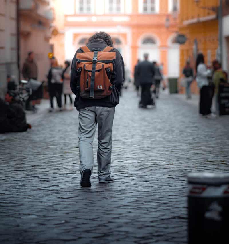 traveler with backpack on cobblestone street
