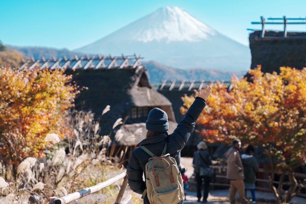 Woman tourist with mount Fuji at Saiko Iyashino Sato Nenba in Autumn season, happy Traveler travel Mt Fuji, Yamanashi, Japan. Landmark for tourist attraction. Japan Travel, Destination and Vacation