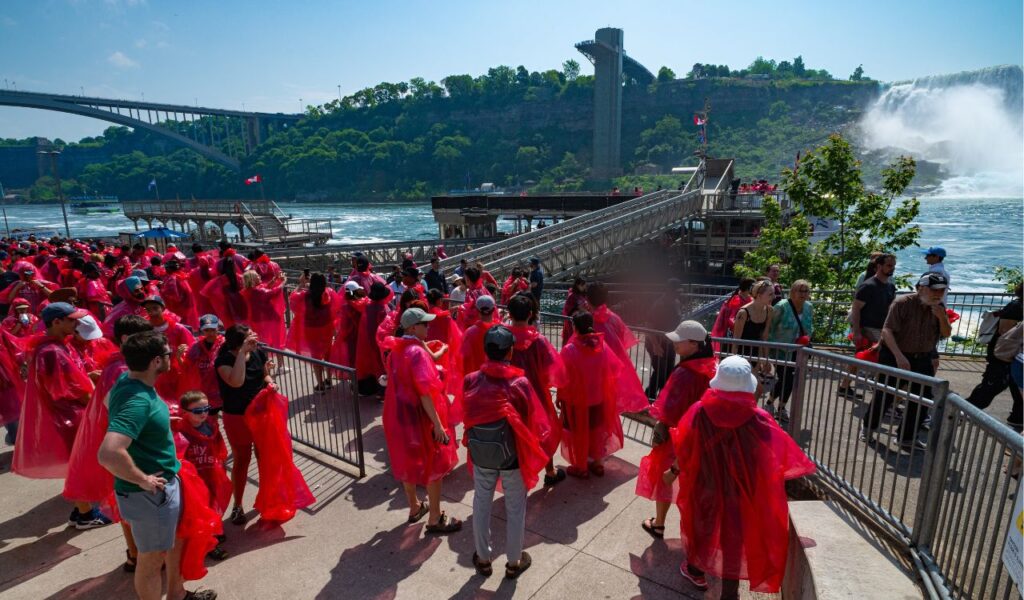 Niagara Falls, ON Canada - June 22, 2025 Visitors in red ponchos wait in line to board one of the Niagara City Cruiser boats that will take them past the U.S.-side falls to Horseshoe Falls.