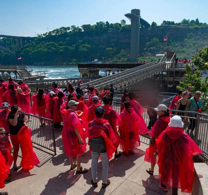 Niagara Falls, ON Canada - June 22, 2025 Visitors in red ponchos wait in line to board one of the Niagara City Cruiser boats that will take them past the U.S.-side falls to Horseshoe Falls.