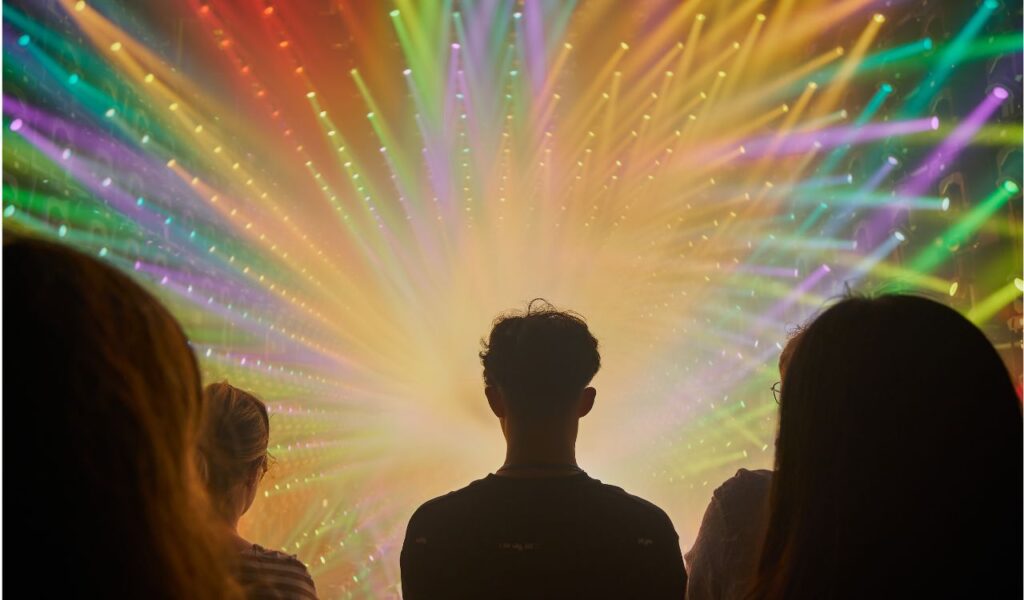 People Silhouetted Against a Vibrant Light Show Starburst - TeamLab Borderless - Tokyo, Japan