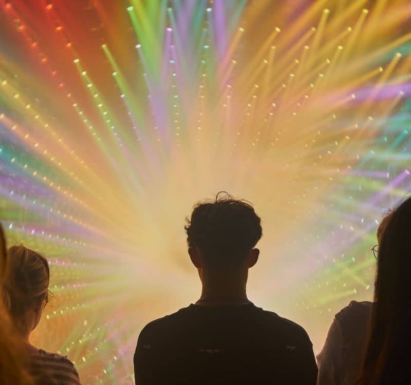 People Silhouetted Against a Vibrant Light Show Starburst - TeamLab Borderless - Tokyo, Japan