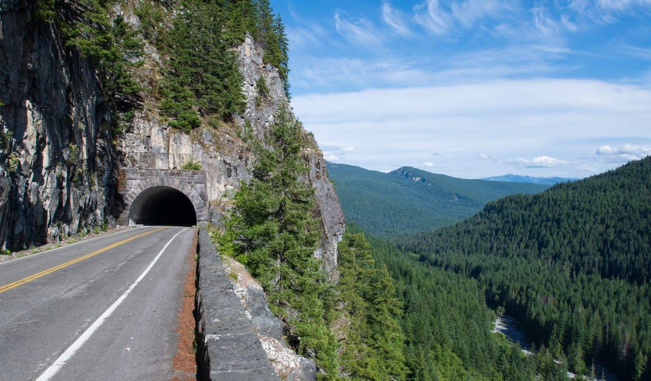 Straight road leading to a dark tunnel at Mount Rainier National Park in Washington, USA