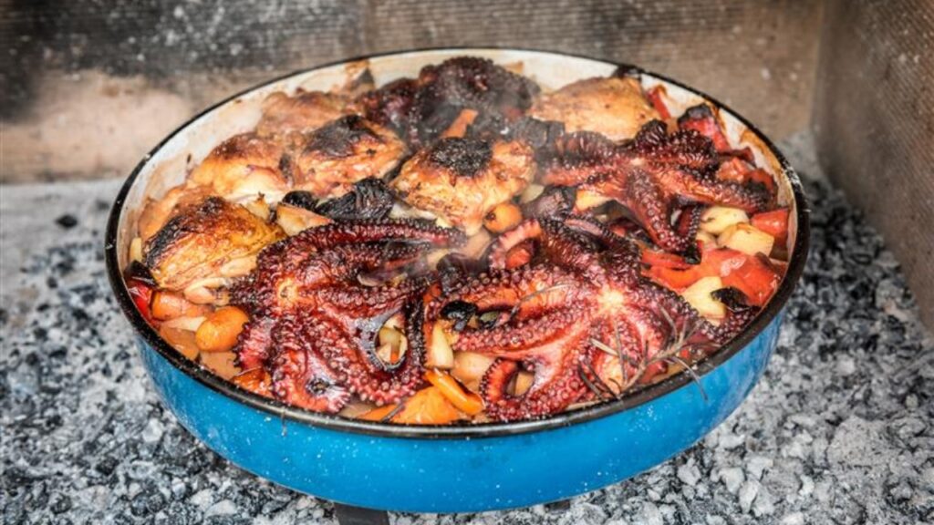 Preparing and Cooking of octopus and chicken in traditional Balkan CroatianGreek Mediterranean meal Peka in metal pots called sac sach or sache or a lid