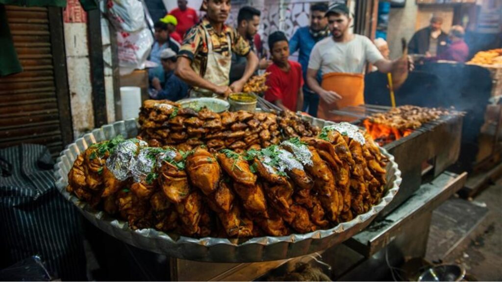 New Delhi, India-Dec 15 2021. Chef at a Aslam chicken shop preparing grilled chicken dishes on a StreetSide shop of a Jama Masjid market. (25 matches)