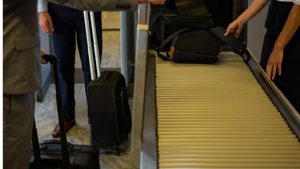 “Airport baggage carousel passengers collecting luggage”