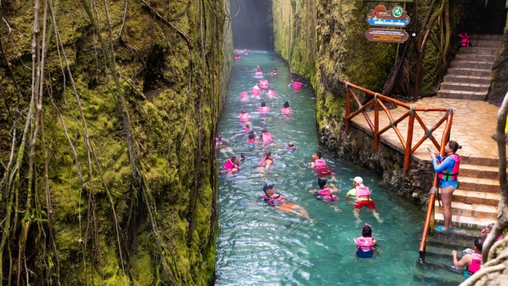 XCARET,MEXICO - APRIL 16,2019 : Visitors enjoying the underground river at the XCaret park on the Mayan Riviera