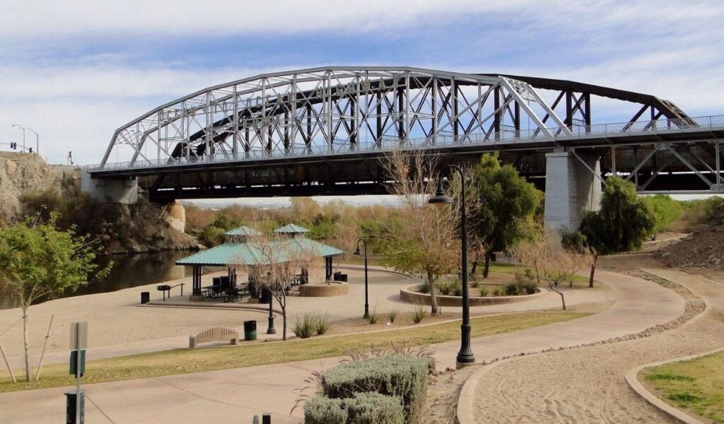 Gateway Park in Yuma, Arizona, featuring shaded picnic areas, walking paths, and the historic Ocean-to-Ocean Bridge spanning the Colorado River.
