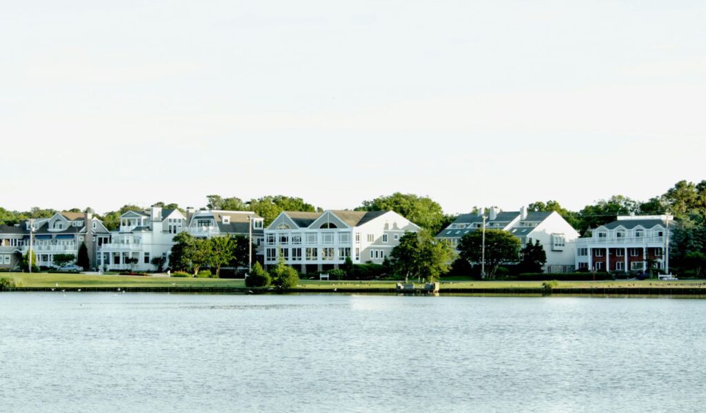 Elegant waterfront homes line the shore near Brandywine Creek State Park in Delaware, framed by trees and reflected in calm waters.