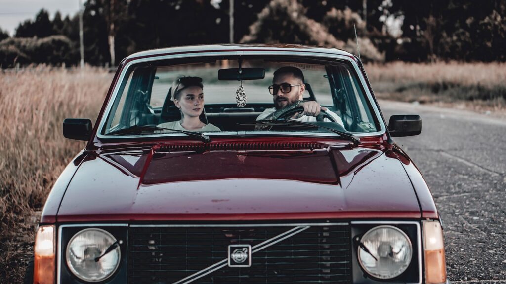 car driving into sunrise with windows down and music