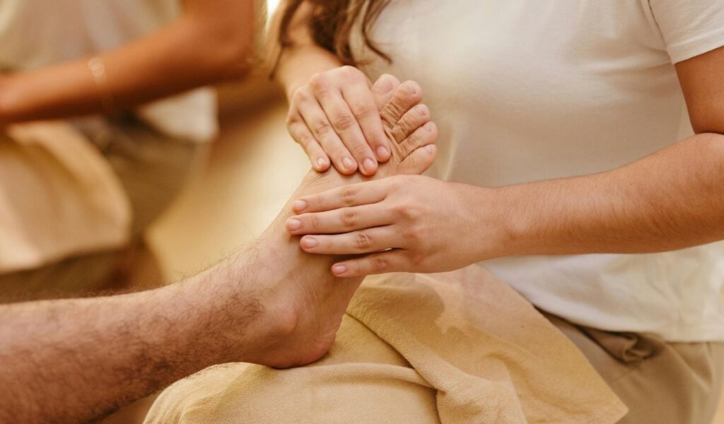 A close-up of a person giving a gentle foot massage, creating a calming and intimate moment between partners.