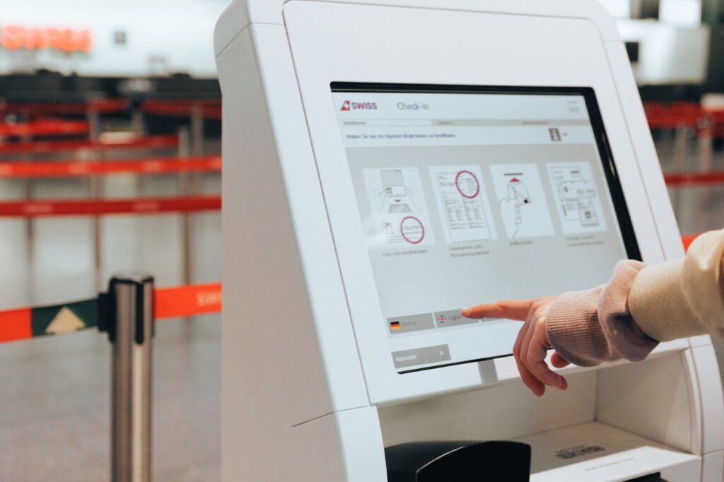 Depicts travelers using a self-service kiosk