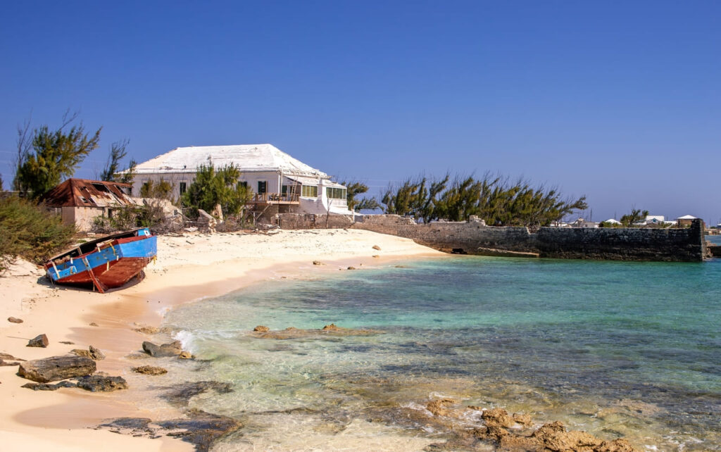 Beach house and boat on the beach at remote and mostly deserted Salt Cay in the Turks and Caicos Islands.