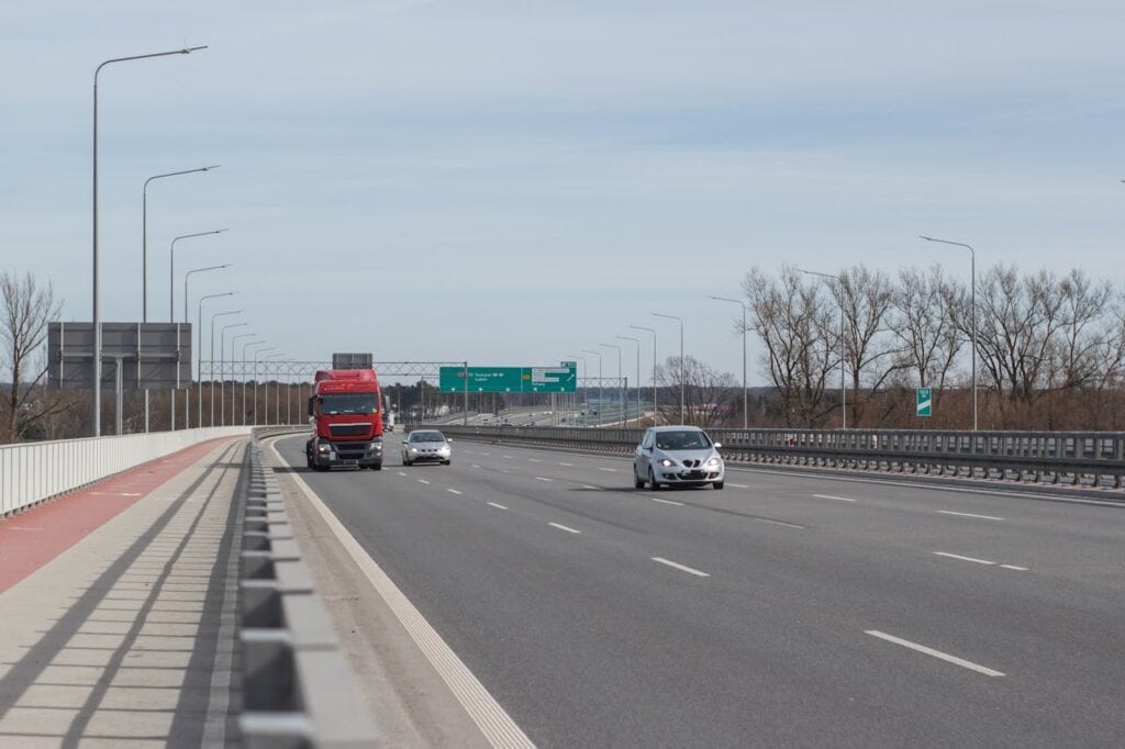 A car passing a large semi-truck safely on the highway
