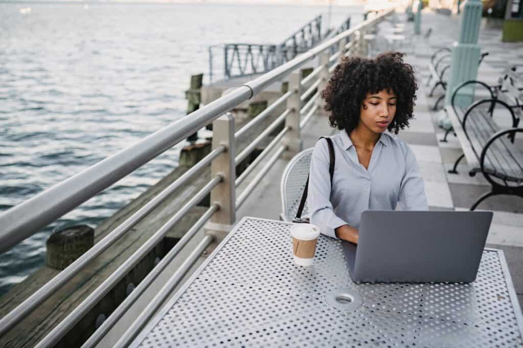 A person working on a laptop in a rental cabin with mountains in the background.
