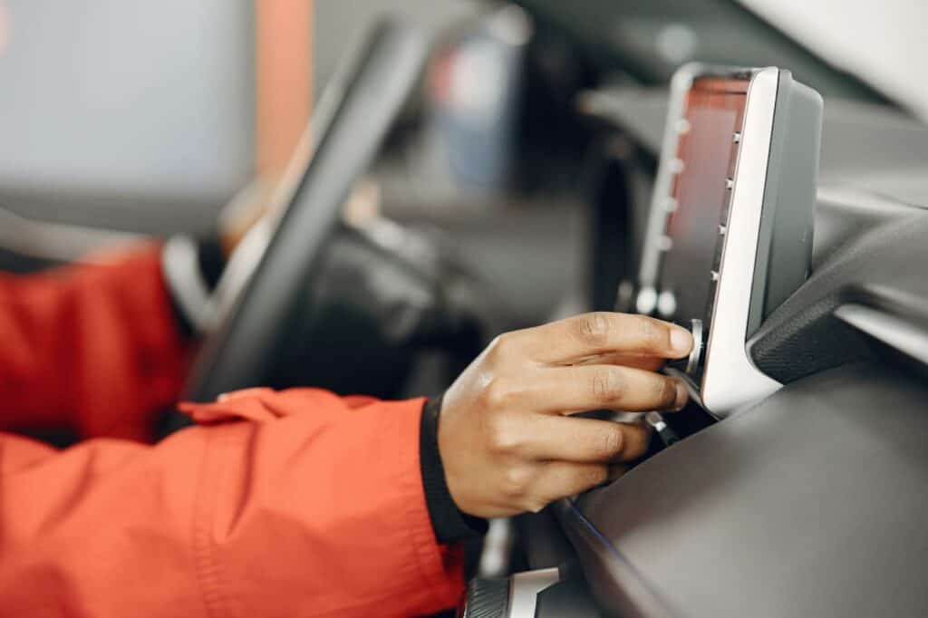 Driver adjusting volume on a car stereo
