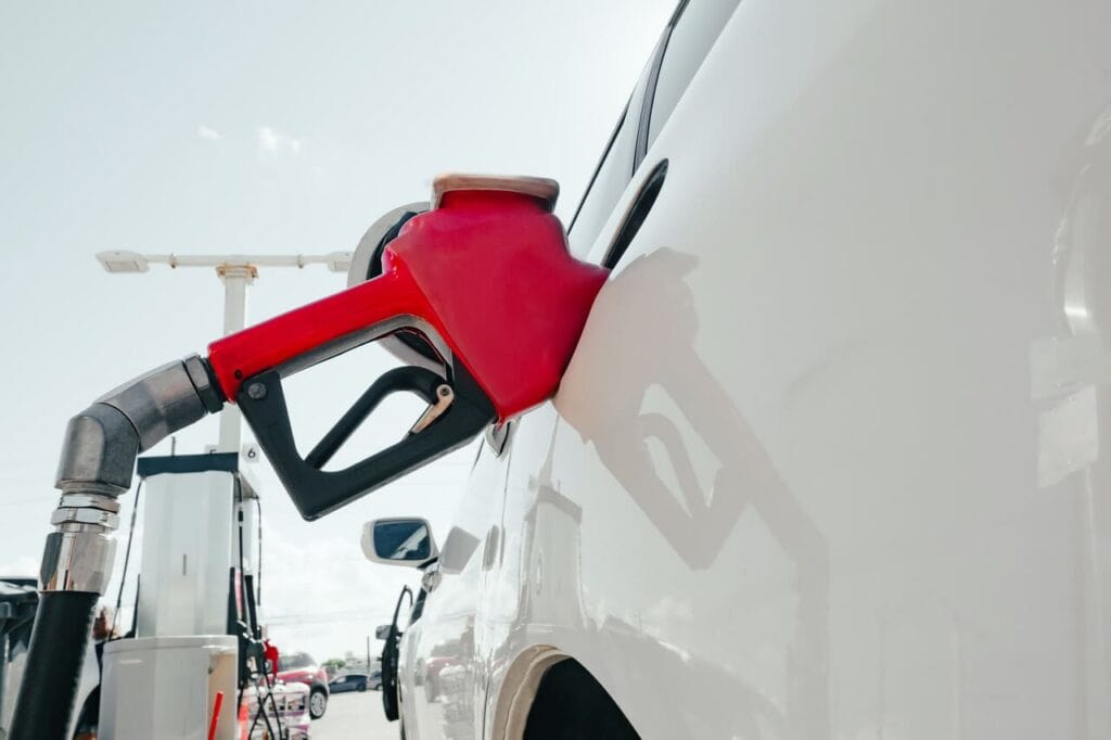 Gas station pump nozzle in a car’s fuel tank.