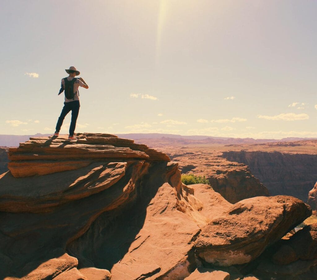 Hiker applying sunscreen or adjusting a sun hat
