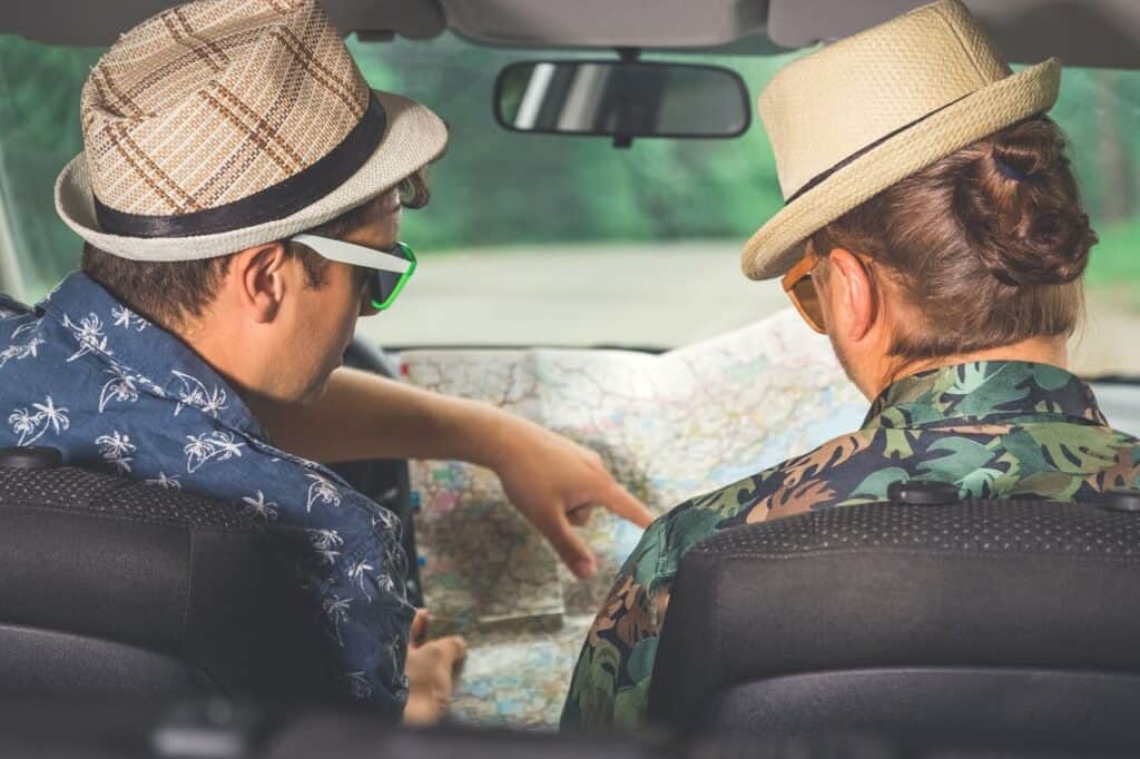 Two travelers sitting in a rental car together.