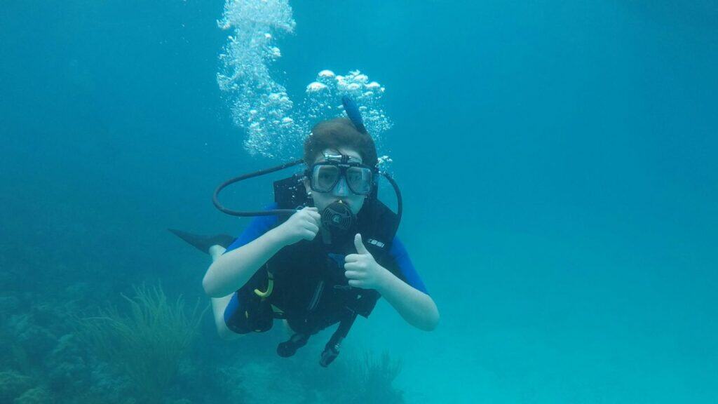 divers practicing underwater hand signals during pre-dive briefing