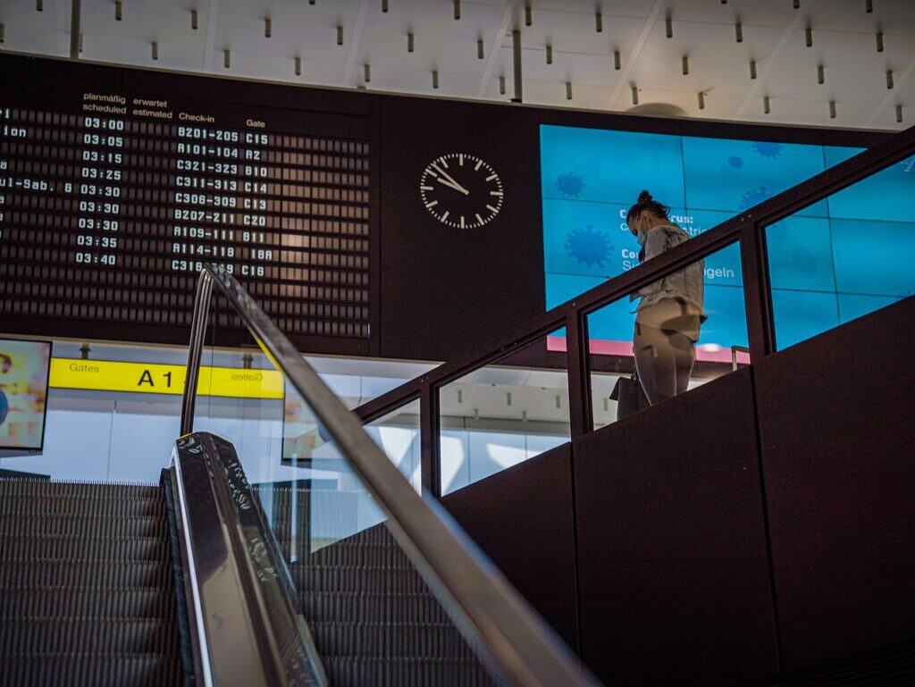 A person at Airport terminal, Schedule board,