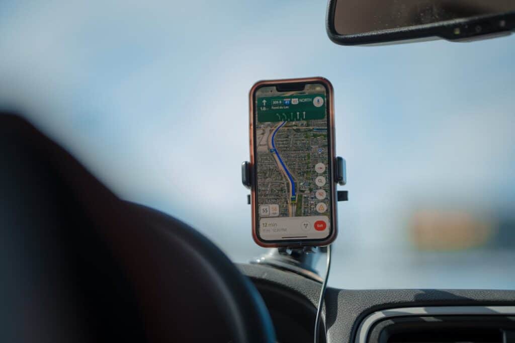dashboard with GPS, phone with map app, scenic highway with GPS directions