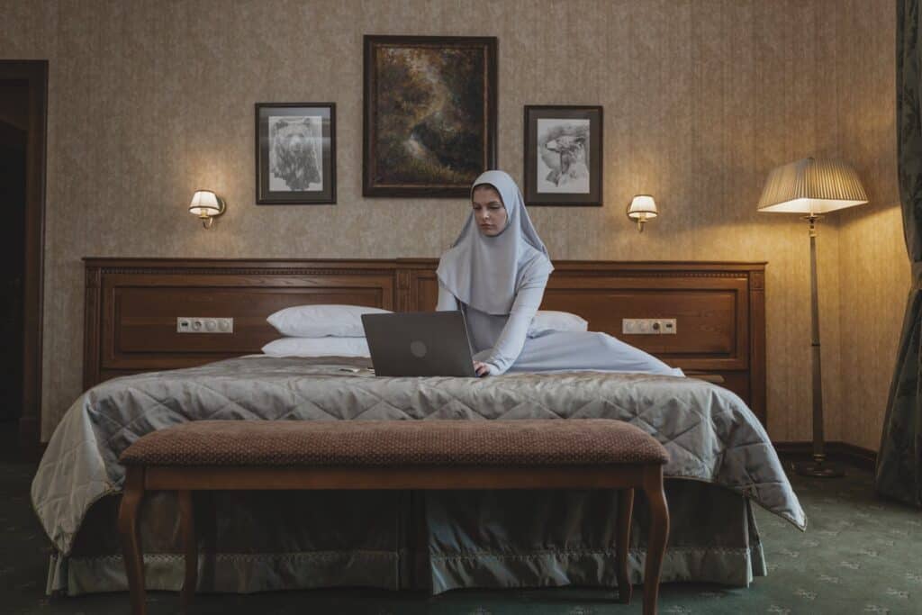 guest using laptop in hotel room,