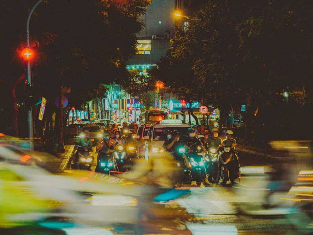 A motorcyclist waiting at a red light at night,